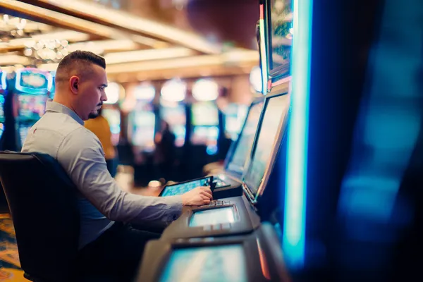 A young woman relaxing with her phone while dynamic casino elements float around her, illustrating the smooth mobile experience offered by the JUGABETT app.