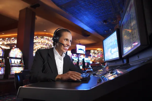 A cheerful woman in traditional clothing using her smartphone during a festive moment, showing how easily the JUGABETT app fits into everyday life.